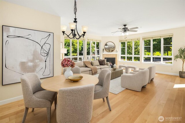 1840 25th Ave NE Unit 210, Issaquah, WA 98029 - dining room with a ceiling fan, light wood-type flooring, a chandelier, and a tile fireplace
