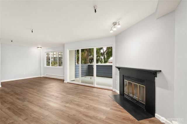 1100AVE NE Harrington Ave NE Unit 211, Renton, WA 98056 - unfurnished living room with a fireplace with flush hearth, baseboard heating, and wood finished floors