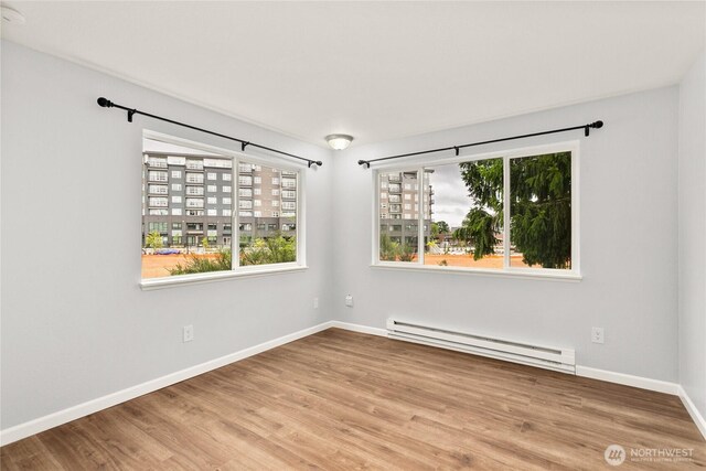 1100AVE NE Harrington Ave NE Unit 211, Renton, WA 98056 - unfurnished room featuring baseboard heating and wood finished floors
