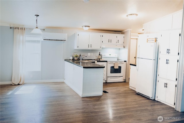 8805 226th Street Ct E Unit 32, Graham, WA 98338 - kitchen with white appliances, a wall mounted AC, a peninsula, dark countertops, and under cabinet range hood