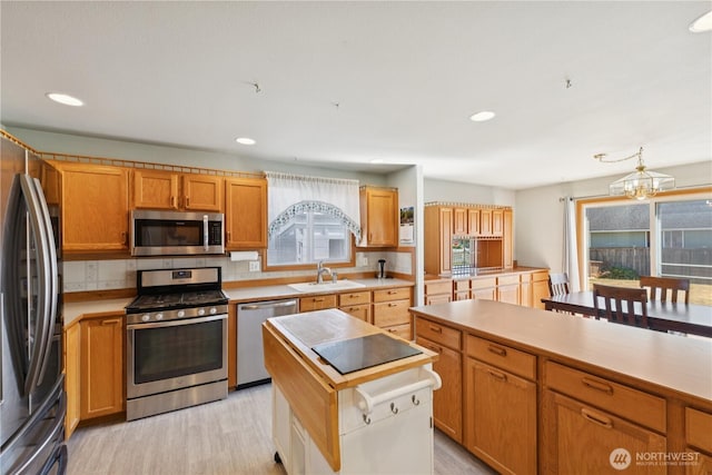 3519 G Ave, Anacortes, WA 98221 - kitchen with stainless steel appliances, light wood finished floors, light countertops, a chandelier, and backsplash