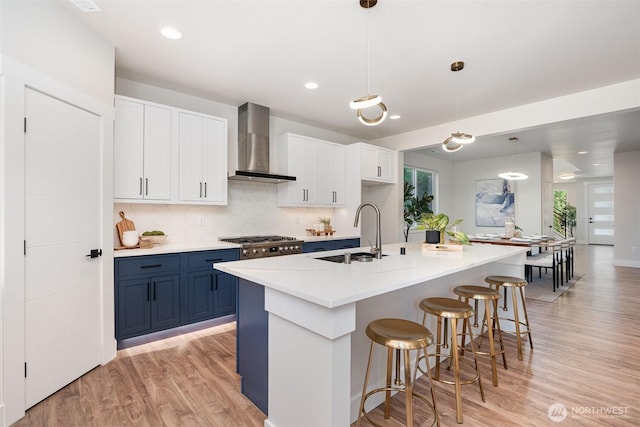 1515 243rd Pl SW Unit A, Bothell, WA 98012 - kitchen featuring wall chimney exhaust hood, light wood-style flooring, plenty of natural light, blue cabinets, and recessed lighting