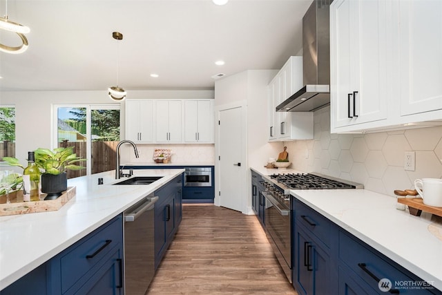 1515 243rd Pl SW Unit A, Bothell, WA 98012 - kitchen with stainless steel appliances, blue cabinetry, wall chimney range hood, light wood-type flooring, and white cabinetry