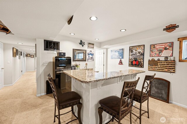 20311 Orting Kapowsin Hwy E, Graham, WA 98338 - kitchen featuring light carpet, a breakfast bar area, recessed lighting, and light stone countertops