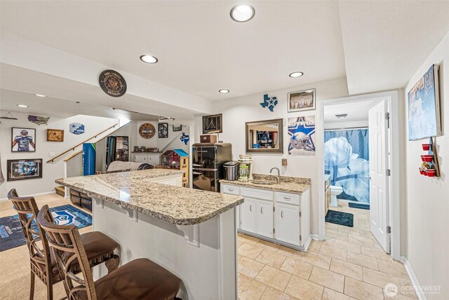 20311 Orting Kapowsin Hwy E, Graham, WA 98338 - kitchen with a breakfast bar area, refrigerator, white cabinets, recessed lighting, and light stone counters