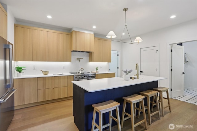 11737 38th Ave NE Unit A, Seattle, WA 98125 - kitchen with light brown cabinetry, modern cabinets, high end refrigerator, a breakfast bar area, and recessed lighting