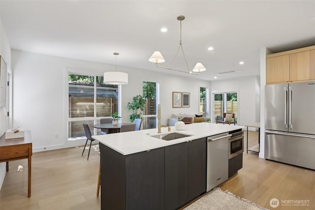 11737 38th Ave NE Unit A, Seattle, WA 98125 - kitchen featuring appliances with stainless steel finishes, light countertops, light wood-style flooring, plenty of natural light, and recessed lighting