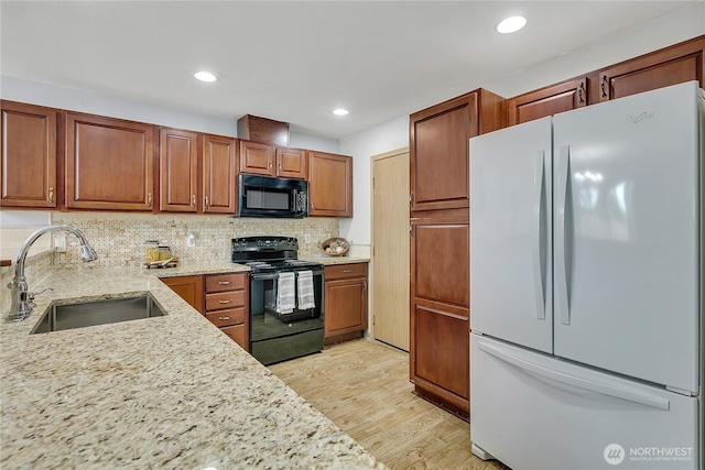 1302 110th St E Unit 37, Tacoma, WA 98445 - kitchen with black appliances, light stone countertops, light wood-style floors, tasteful backsplash, and brown cabinetry