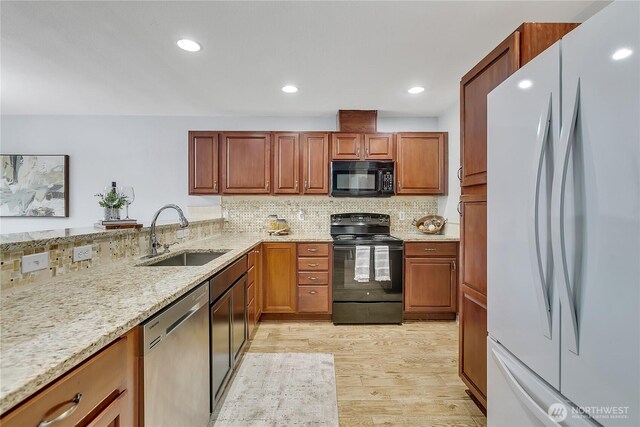 1302 110th St E Unit 37, Tacoma, WA 98445 - kitchen with black appliances, light wood-style flooring, light stone countertops, tasteful backsplash, and brown cabinets