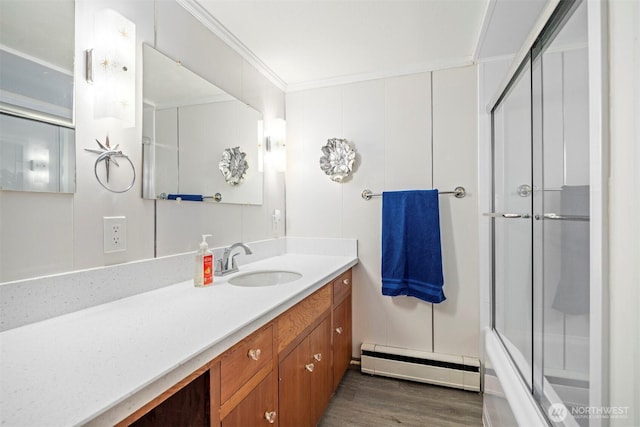 118 Highland Dr, Bellingham, WA 98225 - full bathroom with a baseboard radiator, vanity, wood finished floors, crown molding, and combined bath / shower with glass door
