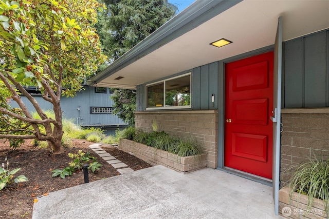 118 Highland Dr, Bellingham, WA 98225 - view of exterior entry with board and batten siding, a patio, and brick siding