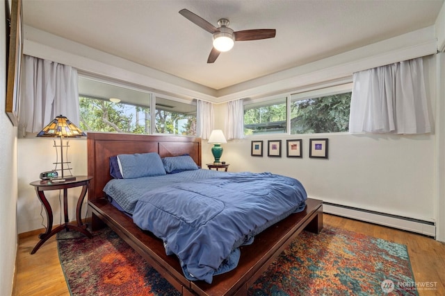 118 Highland Dr, Bellingham, WA 98225 - bedroom with a baseboard heating unit, wood finished floors, and a ceiling fan