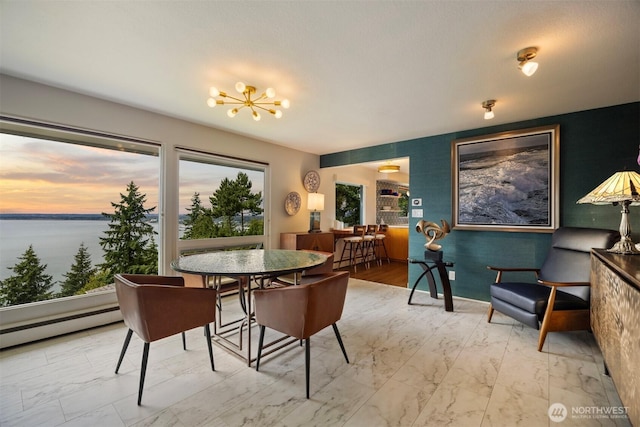 118 Highland Dr, Bellingham, WA 98225 - dining space featuring marble look tiles, a chandelier, a water view, and a baseboard heating unit