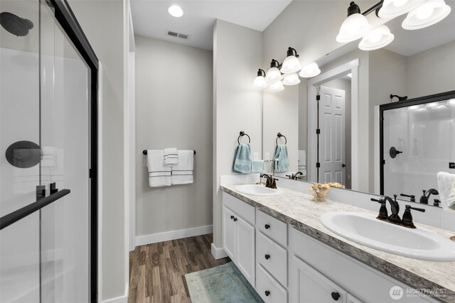 397 N Foster St, Buckley, WA 98321 - full bathroom featuring a stall shower, double vanity, and wood finished floors