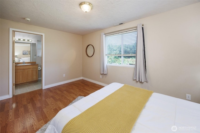 2537 Kristine Ct, Centralia, WA 98531 - bedroom featuring wood finished floors, ensuite bath, and a textured ceiling