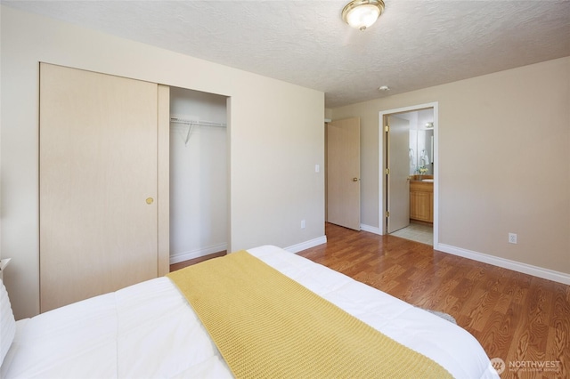 2537 Kristine Ct, Centralia, WA 98531 - bedroom featuring a closet, wood finished floors, connected bathroom, and a textured ceiling