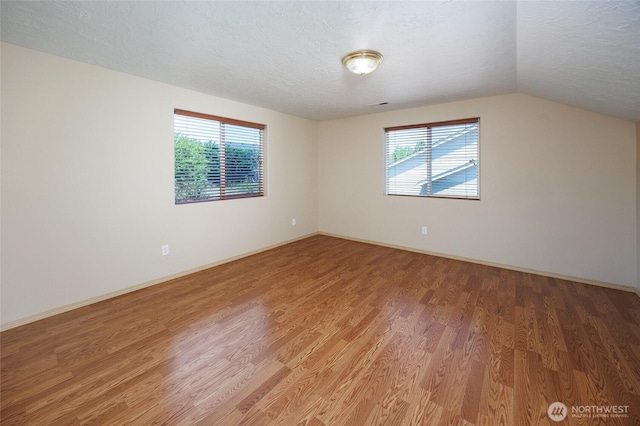 2537 Kristine Ct, Centralia, WA 98531 - unfurnished room featuring a textured ceiling, light wood-style flooring, and vaulted ceiling