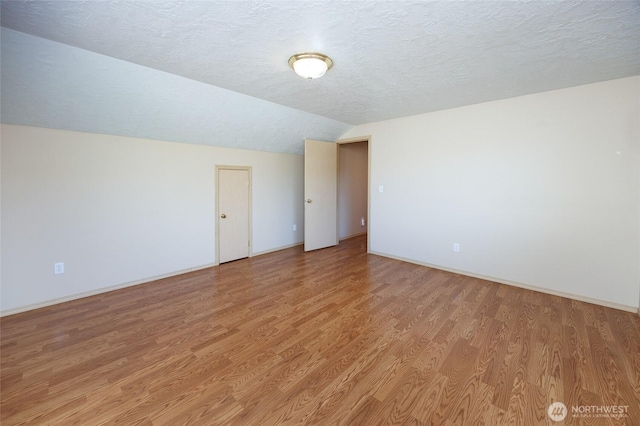 2537 Kristine Ct, Centralia, WA 98531 - empty room with lofted ceiling, light wood finished floors, and a textured ceiling
