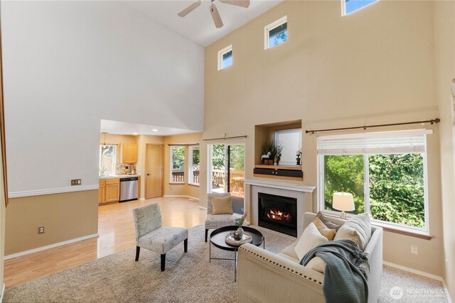 2819 Z St SE, Auburn, WA 98002 - living area featuring a high ceiling, a fireplace, ceiling fan, and light wood-style floors