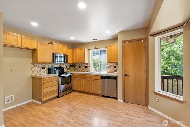 2819 Z St SE, Auburn, WA 98002 - kitchen with stainless steel appliances, light countertops, decorative backsplash, light wood-style floors, and recessed lighting