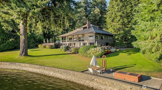 5222 Mahncke Rd SW, Longbranch, WA 98351 - back of house featuring a water view, a lawn, and a chimney