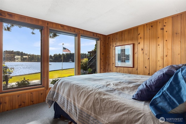 5222 Mahncke Rd SW, Longbranch, WA 98351 - bedroom with carpet floors, wood walls, access to exterior, and a water view