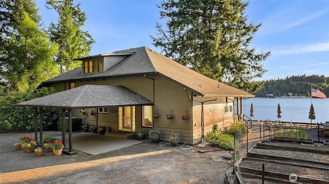 5222 Mahncke Rd SW, Longbranch, WA 98351 - view of front facade featuring a shingled roof, a water view, and driveway
