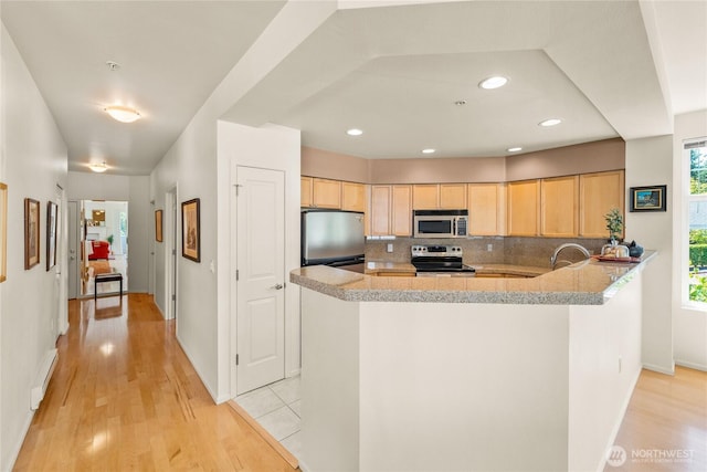 2244 SE 132nd Ave Unit B217, Bellevue, WA 98005 - kitchen featuring stainless steel appliances, light brown cabinets, light wood-style flooring, tasteful backsplash, and recessed lighting