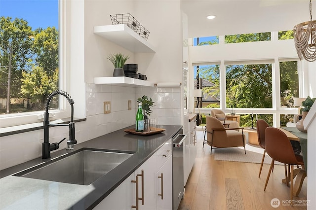 2610 E Yesler Way Unit A, Seattle, WA 98122 - kitchen featuring light wood-style flooring, white cabinets, dark countertops, tasteful backsplash, and open shelves