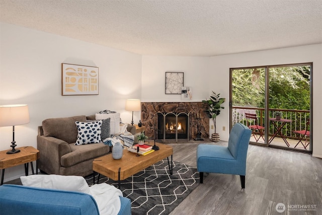 14132 74th Pl NE Unit 16D, Kirkland, WA 98034 - living room featuring wood finished floors, a fireplace, and a textured ceiling