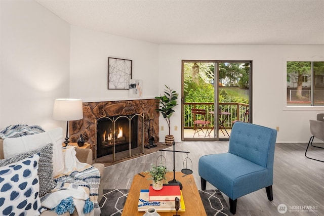 14132 74th Pl NE Unit 16D, Kirkland, WA 98034 - living room featuring a fireplace, wood finished floors, and a textured ceiling