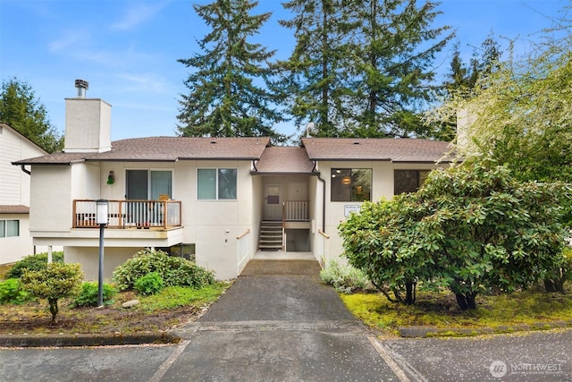 14132 74th Pl NE Unit 16D, Kirkland, WA 98034 - view of front of house featuring a chimney, stucco siding, and roof with shingles