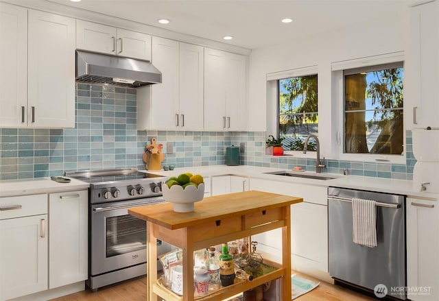 10419 41st Ave SW Unit A & B, Seattle, WA 98146 - kitchen featuring appliances with stainless steel finishes, under cabinet range hood, light countertops, white cabinets, and tasteful backsplash