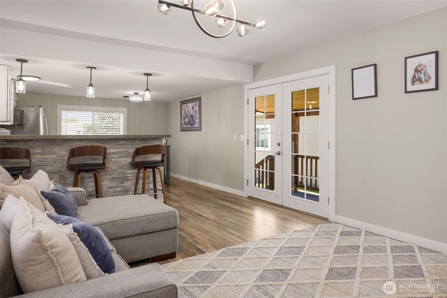 8730 206th St SE Unit 10, Snohomish, WA 98296 - living room featuring french doors, light wood-type flooring, and a chandelier