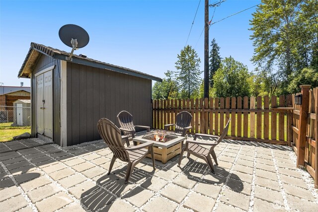 8730 206th St SE Unit 10, Snohomish, WA 98296 - view of patio / terrace featuring a fire pit and a storage shed