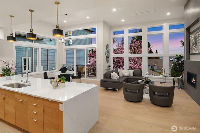 240 W Lake Sammamish Pkwy SE, Bellevue, WA 98008 - kitchen with light wood-style floors, open floor plan, pendant lighting, recessed lighting, and a glass covered fireplace
