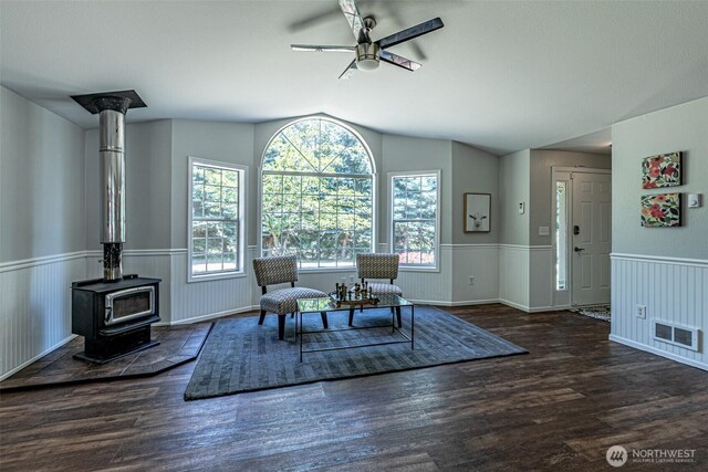 18920 217th Ave E, Orting, WA 98360 - dining space featuring a ceiling fan, a wood stove, a wainscoted wall, lofted ceiling, and wood finished floors