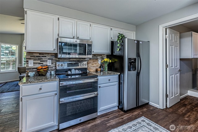 18920 217th Ave E, Orting, WA 98360 - kitchen with stainless steel appliances, dark wood-style flooring, stone countertops, and white cabinetry