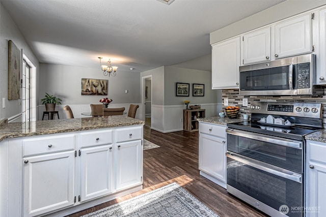 18920 217th Ave E, Orting, WA 98360 - kitchen featuring appliances with stainless steel finishes, white cabinets, a chandelier, a peninsula, and dark wood-style floors