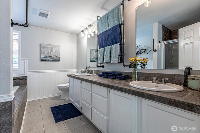 18920 217th Ave E, Orting, WA 98360 - bathroom with double vanity, a wainscoted wall, a shower stall, tile patterned floors, and tiled tub