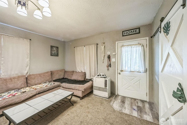 610 Westlake Ave, Morton, WA 98356 - living room with a textured ceiling, heating unit, wood finished floors, a chandelier, and a barn door