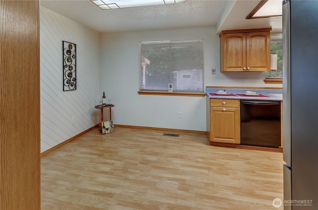 7127 Fair Oaks Loop SE, Olympia, WA 98513 - kitchen featuring freestanding refrigerator, dishwashing machine, light wood-type flooring, healthy amount of natural light, and wood walls