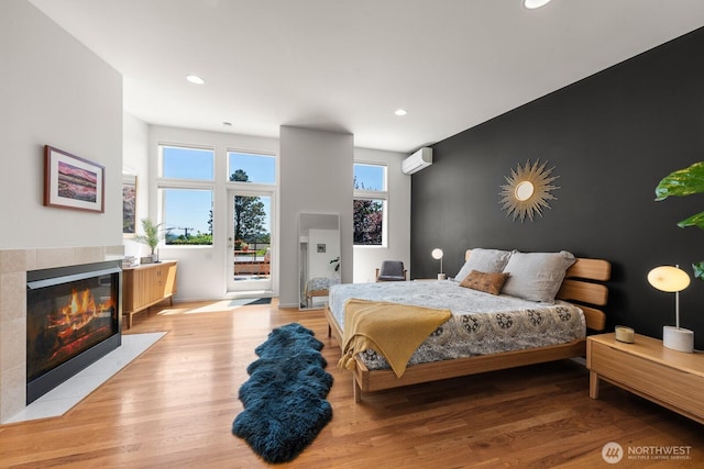 3516 NE 43rd St, Seattle, WA 98105 - bedroom with access to exterior, light wood-style flooring, a tile fireplace, a wall mounted AC, and recessed lighting