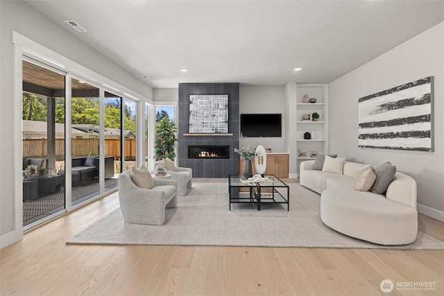 16429 Snohomish Ave SE, Clearview, WA 98296 - living area with wood finished floors, a tile fireplace, recessed lighting, and built in shelves