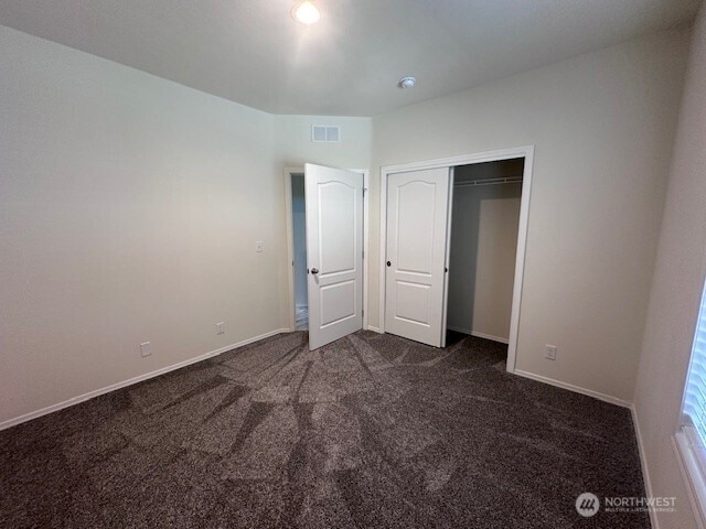 2101 S 324th St Unit 193, Federal Way, WA 98003 - unfurnished bedroom with dark carpet and a closet