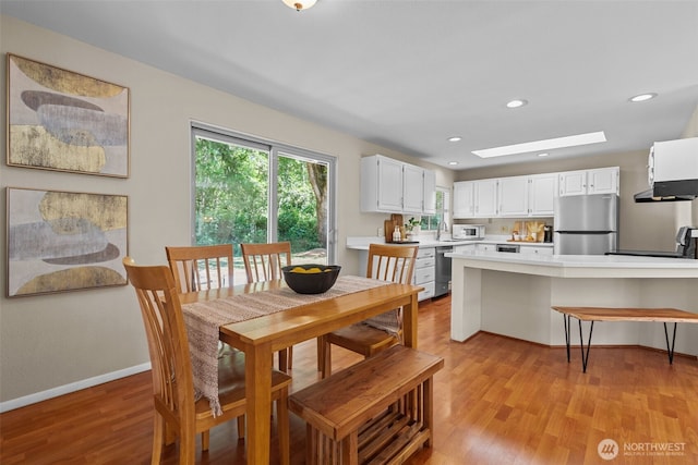 8618 212th St NE, Arlington, WA 98223 - dining space featuring light wood-style floors, a skylight, and recessed lighting