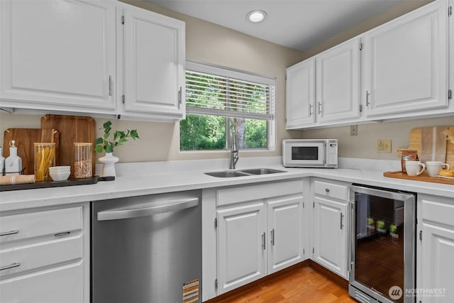 8618 212th St NE, Arlington, WA 98223 - kitchen featuring dishwasher, beverage cooler, white microwave, light countertops, and white cabinetry