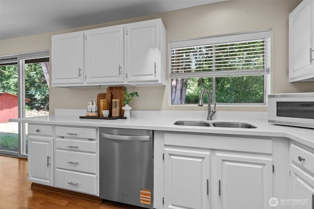 8618 212th St NE, Arlington, WA 98223 - kitchen with stainless steel dishwasher, white microwave, light countertops, and white cabinetry