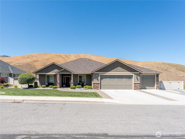2038 Maiden Ln, Wenatchee, WA 98801 - craftsman-style home featuring an attached garage, concrete driveway, a mountain view, and stone siding