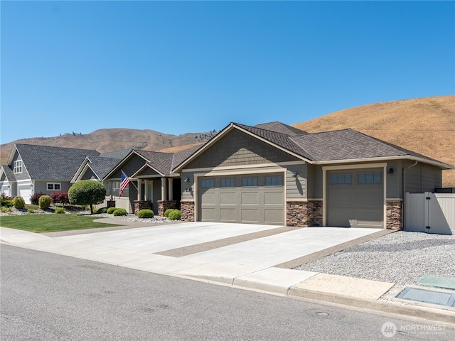 2038 Maiden Ln, Wenatchee, WA 98801 - craftsman house with an attached garage, driveway, a mountain view, and stone siding